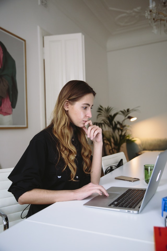 Pensive female academic engages in research via her personal computer 