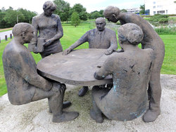 Statues of men and women appear to be discussing research ideas in local park 