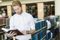Man looks at research book 