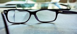 Reading glasses rest on academic manuscript 