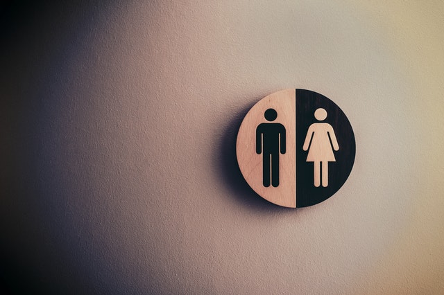  A gender neutral sign accompanied by the word 'everyone' is glued onto toilet door  