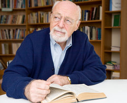 Pensive man holding book looks away